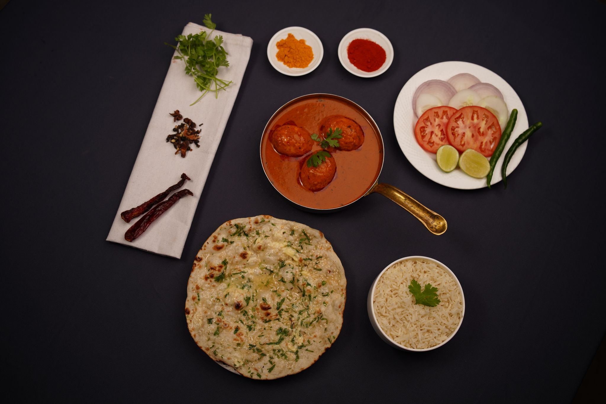 Enjoy an authentic Indian curry meal with naan bread, rice, and spices.