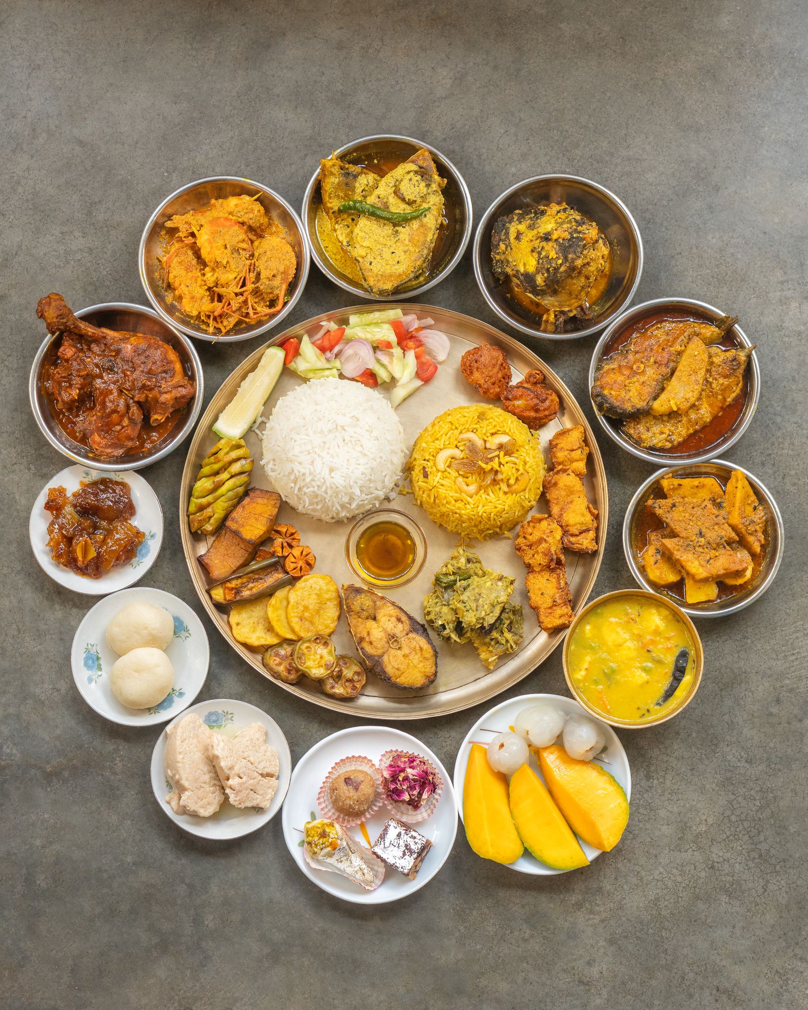 Top view of a traditional Indian thali with a variety of colorful and delicious dishes arranged on a table.